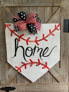 baseball home plate door hanger with hand-lettered home and black and red bow