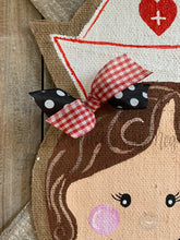 Load image into Gallery viewer, nurse door hanger with nurse hat and red and black bow